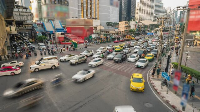 Fast moving transport on the crossroad Sukhumvit and Asok Montri street in Bangkok city. Traffic of vehicles and people on highway and intersection streets in Metropolis. Time lapse of rush hour 