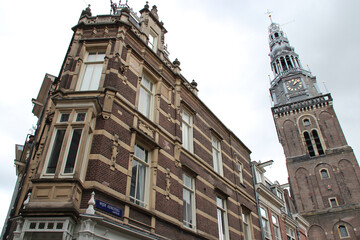 old brick houses and clock tower of a church in amsterdam (the netherlands) 