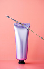 Shined cosmetic tube mock up. Plastic packaging of professional skin care cream and lavender flower.