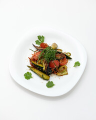 Thai salad with vegetables, noodles and teriyaki sauce. Dish is decorated with sesame seeds and parsley on white plate. Asian cuisine. Vegetarian food. White background. View from above. Copy space. 