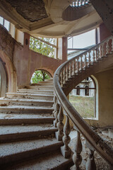 Old abandoned mansion with decorated spiral staircase