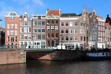 canal, river and old brick houses in amsterdam (the netherlands) 