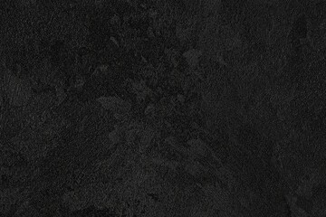 Dark black grunge textured concrete stone wall background.