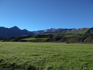 Fototapeta na wymiar green valley at the foot of the mountains. pasture for cows and sheep.