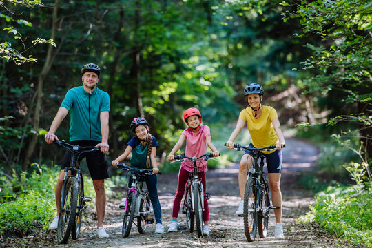 Young family with little children at bike trip together in nature.