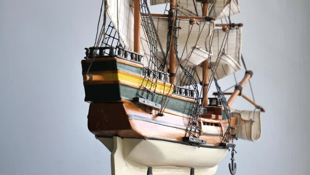 4K video of wooden sailboat scale model with fabric sails and thread ropes rotates around closeup  
