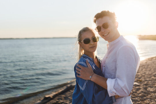 Young cupple cuddling during sunset at sea.
