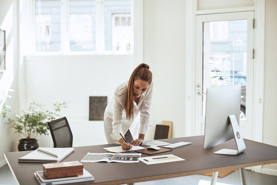 Young female architect sketching a design at her office desk