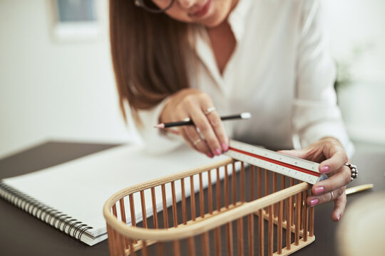 Female architect sitting at her desk examining a scale model