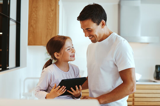 Laughing dad and girl using a tablet