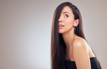 Those days of damaged hair are long gone. an attractive young woman posing alone in the studio with her hair covering half of her face.