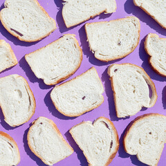 Sliced ​​bread on purple background. Food pattern concept.