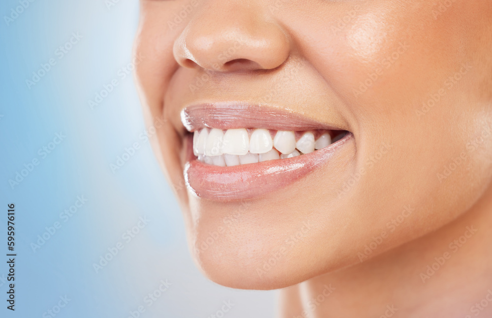 Wall mural Never hide a smile so beautiful. Closeup shot of an unrecognizable woman smiling against a blue background.