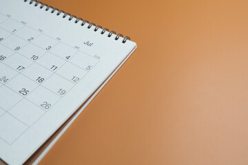close up of calendar on the brown table background, planning for business meeting or travel planning concept