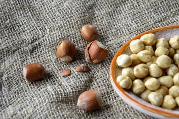 Ripe filbert kernels and hazelnuts in a shell on burlap background. Healthy nutrition. Close-up. Copy space. Shallow depth of field. Selective focus.