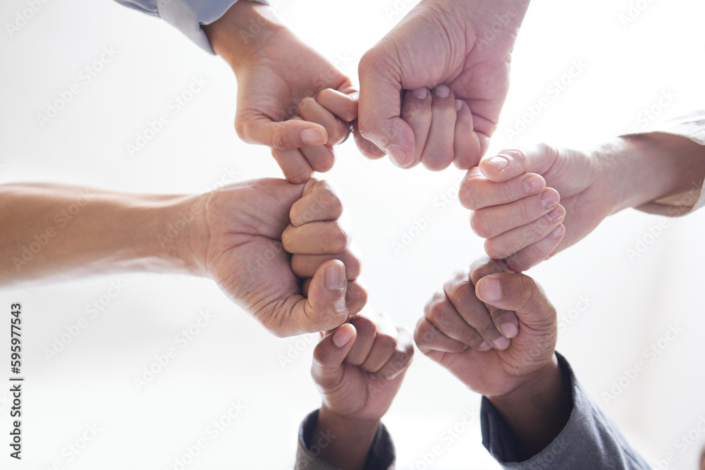 Poster There is more power in unity than division. Shot shot of a group of unidentifiable businesspeople joining their fists together in a unity.