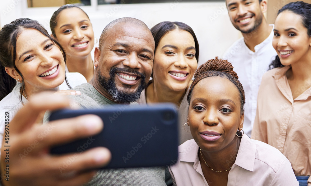 Poster clowning around. a group of colleagues taking a selfie in a office.