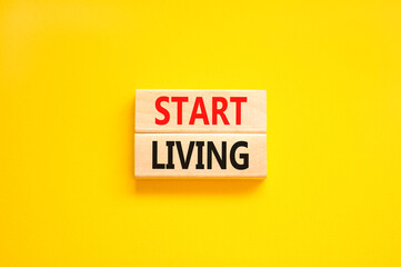 Start living symbol. Concept words Start living on beautiful wooden block. Beautiful yellow table yellow background. Business and Start living concept. Copy space.