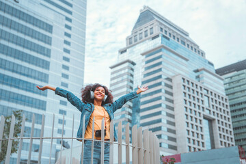 Happy joyful young tourist African American woman open arms enjoy in the center of a city urban, Go...