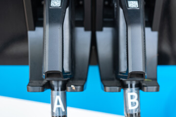 An EV charger CCS type 2 DC plug head with symbol label at the electricity charging station. Clean energy for transportation equipment object. Close-up and selective focus.