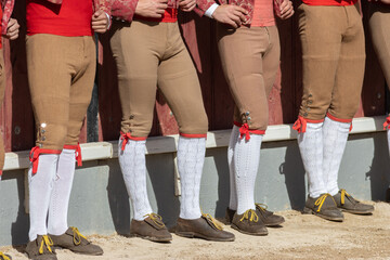 Tourada - forcados in beige pants standing in a row on arena