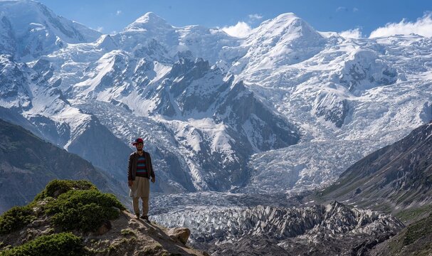 Gar&ccedil;on devant un glacier et de hautes montagnes enneig&eacute;es