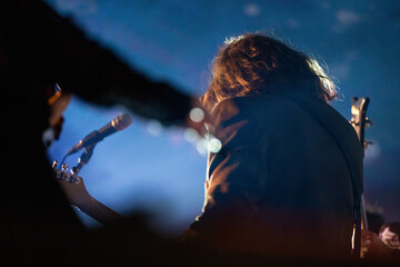 Band playing music and a gig in a venue, close up of a rock band playing guitars and instruments.