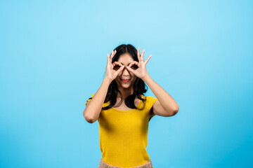 Portrait, Asian woman wearing yellow tights, standing in studio, raised two hands thumb index...