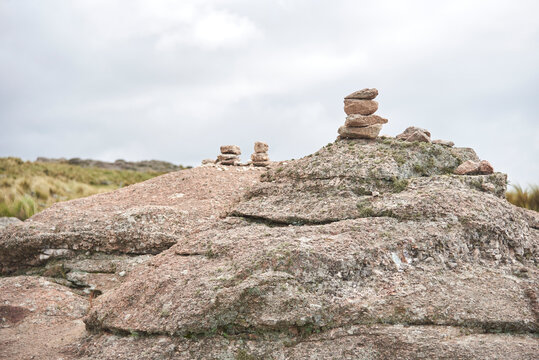 Pircas, piles of stones that serve as trail markers for hikers to follow the correct way, in Los Gigantes, Cordoba, Argentina. Nature travel concept.