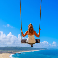 Woman sitting on swing flying in blue sky with view of sea or ocean- vacation,travel, tourism,...