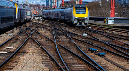 Panorama of railway infrastructure with two trains arriving at Brussels main station, Belgium. Network of tracks, switches overhead lines and multiple units on a sunny day in european metropole.