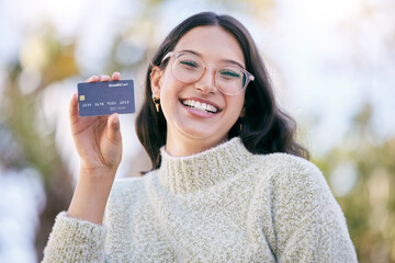 I made the smart choice. a happy young woman holding up a credit card while standing outside. - obrazy, fototapety, plakaty