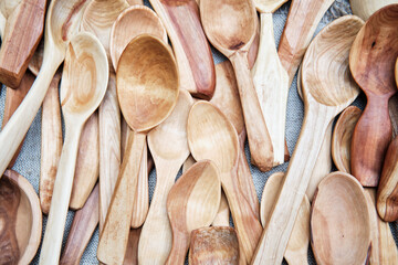 Wooden spoons handmade from different types of wood, lying on table