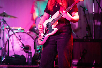 Band playing music and a gig in a venue, close up of a rock band playing guitars and instruments.