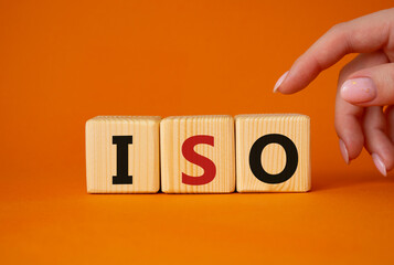 ISO standards quality control symbol. Concept word ISO on wooden cubes. Businessman hand. Beautiful...