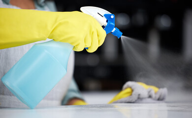 A clean home is like a breath of fresh air. a woman using a spray bottle and cloth while cleaning a...
