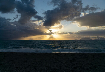 Obraz premium Beautiful and relaxing sunset at milazzo beach with cloudy blue sky and mediterranean sea 