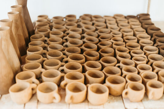 Unfinished clay cups on wooden table
