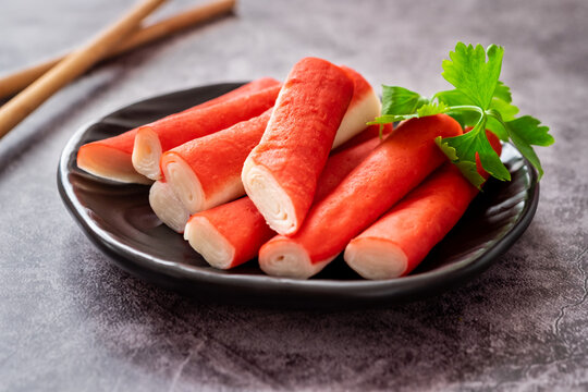 Fresh crab sticks on black plate