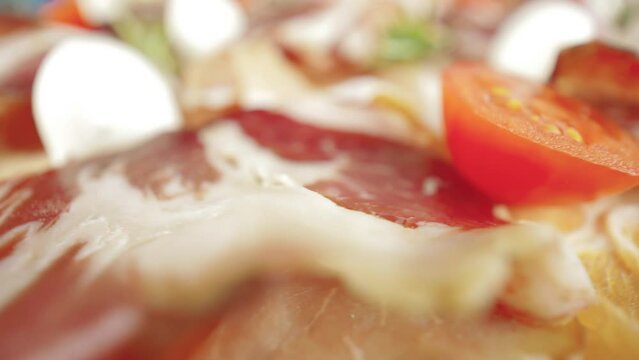 Raw pork ham. Slices of pork dried ham, Prosciutto Toscano. Close up view