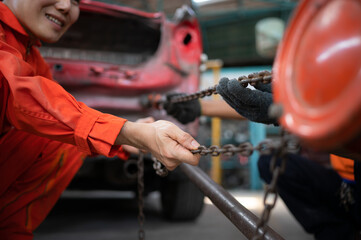 To return the automobile body to its former shape, an auto repair mechanic uses a machine to pull...