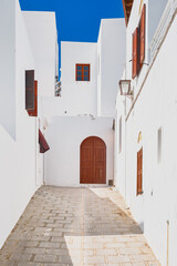 Vertical shot, quiet Greek street on the outskirts of the city of Lindos, Rhodes island, Greek islands of the Dodecanese archipelago, Europe. Holidays and travel around the islands