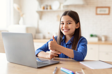 Girl Learning Online On Laptop Gesturing Thumbs Up At Home