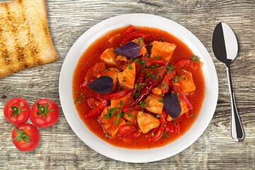 Bowl of hot tasty soup dish on the desk