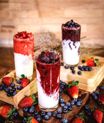 Healthy vitamin. Summer berries yoghurt smoothie in glass on rustic wooden table