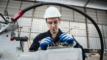 Industrial engineers are in charge of controlling the automated robot arms machine welding robots in industrial manufacturing factory.