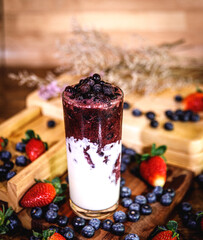 Healthy vitamin. Summer berries yoghurt smoothie in glass on rustic wooden table