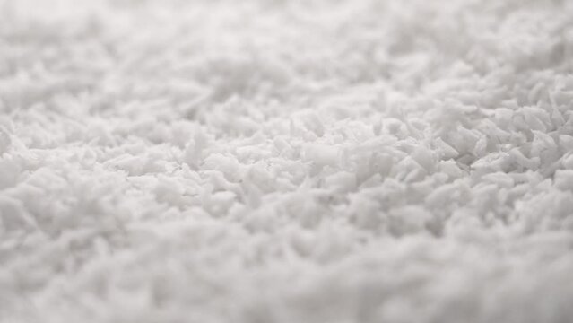 Grated coconut flakes falling in slow motion close up. Nut natural ingredient
