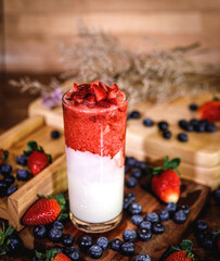 Healthy vitamin. Summer berries yoghurt smoothie in glass on rustic wooden table