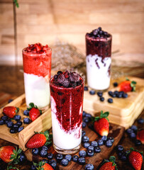Healthy vitamin. Summer berries yoghurt smoothie in glass on rustic wooden table